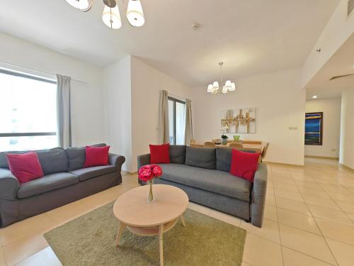 a living room with a couch and a table at Beautiful 2BR & 4BR Apartments on JBR Beach, Walking Distance to Bluewaters Island - By Sunkissed Holiday Homes in Dubai