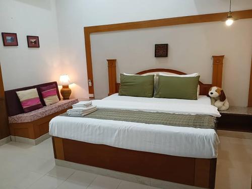 a bedroom with a large bed with a dog sitting on it at Rosie Garden & Home in Ban Bung