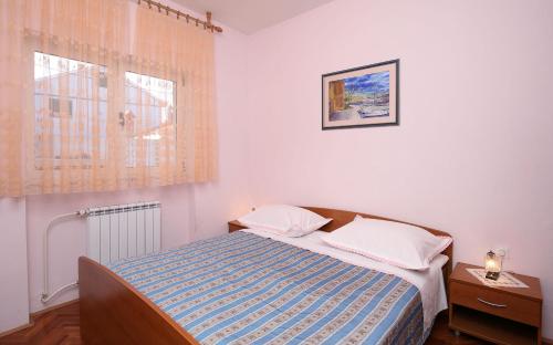 - une petite chambre avec un lit et une fenêtre dans l'établissement Apartments Sara, à Kali