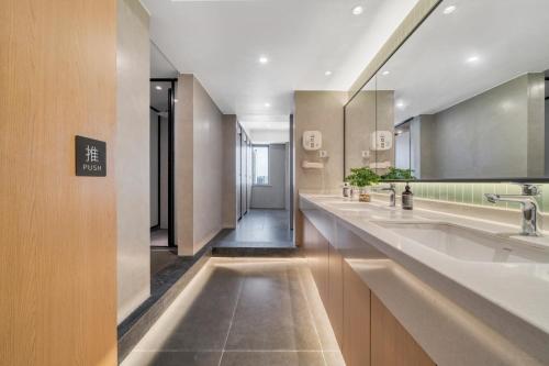 a large bathroom with two sinks and a mirror at Wander Lodge Youth Hostel in Chengdu