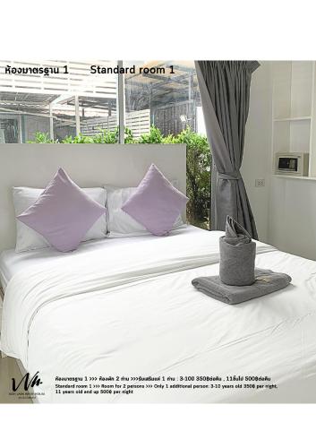 a bedroom with a bed with purple pillows at Koh Larn White House in Ko Larn