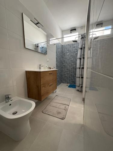 a bathroom with a sink and a toilet and a shower at Lu Sule Lu Mare Lu Ientu in Torre Lapillo