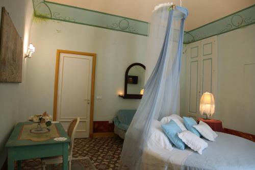 コラートにあるLocus Amoenus Luxury Roomsのベッドルーム1室(天蓋付きベッド1台、テーブル付)