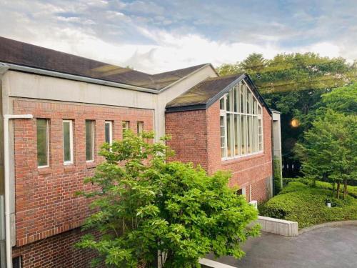 a brick building with a tree in front of it at Fuji Shoei kaikan in Fuji