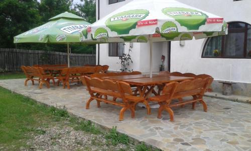 a group of tables and umbrellas on a patio at Vila Madudu in Vălenii de Munte