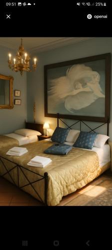 two beds in a room with a painting on the wall at Il Casale dell'Abate B&B - GUARDEA UMBRIA in Cocciano