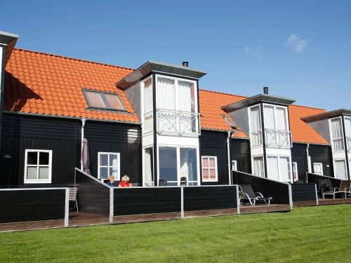 dos personas sentadas en el porche de una casa en 6 person holiday home in Juelsminde-By Traum, en Juelsminde
