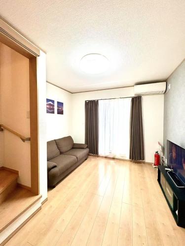 an empty living room with a couch and a window at 夏様二条南 6 min walk Nijo St, Entire private house, 3 bedrooms, Up to 6 guests, 2 toilets in Kyoto
