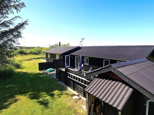 ein Haus mit einem Zaun davor in der Unterkunft 6 person holiday home in Hirtshals-By Traum in Hirtshals