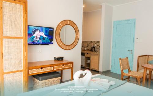 a living room with a tv and a table at de'Govin Hotel in Tjakranegara