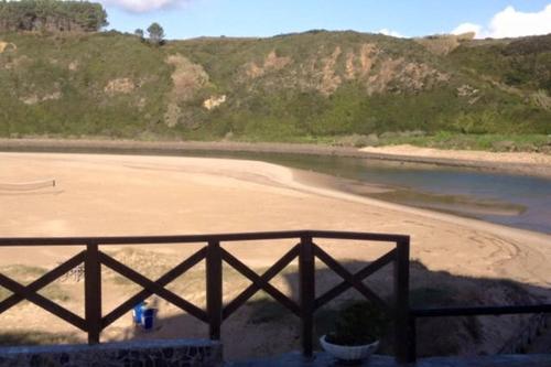 a beach with a fence and a fire hydrant at Apartamentos Cavaco in Odeceixe