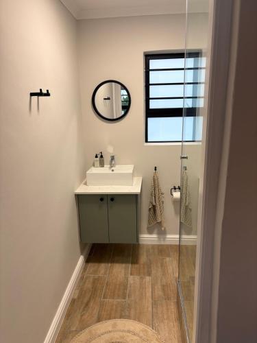 a bathroom with a sink and a mirror at Suburban Bliss in Stellenbosch