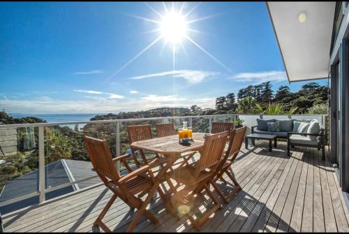 a wooden deck with a table and chairs on a balcony at Palm Breeze Getaway-Waiheke Island Resort Premium 95m Villa in Waiheke Island