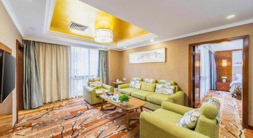 a living room with green couches and a table at Liyuan Hotel in Shenzhen