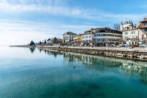 un cuerpo de agua con edificios y un río en NYON - SUPERB flat by the lake, en Nyon