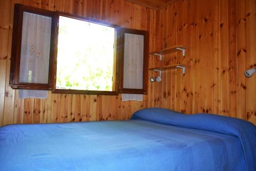 a bedroom with a blue bed in a wooden room at Villaggio Camping Valdeiva in Deiva Marina