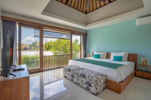 a bedroom with a bed and a tv and a balcony at Lacasa2 Villa Legian With Butler in Legian