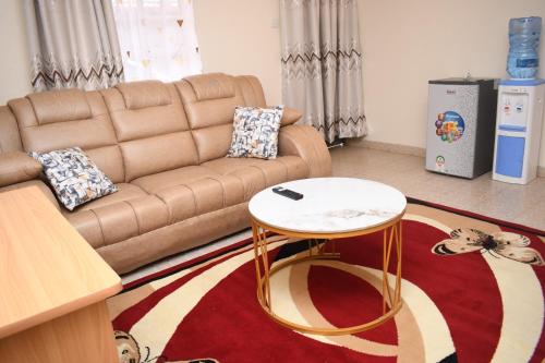 a living room with a couch and a table at Lavender Cute Homes in Thika