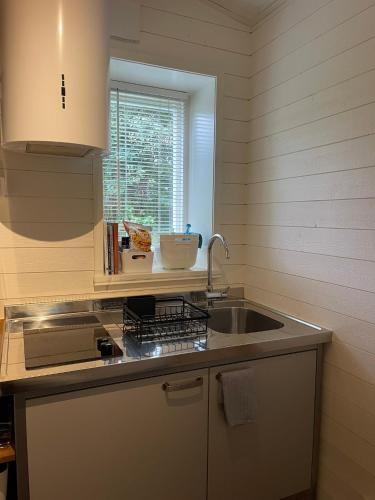 a kitchen with a sink and a window at Skärgårdsidyll i Stavsnäs Idyllic Archipelago Retreat in Stavsnäs in Stockholm