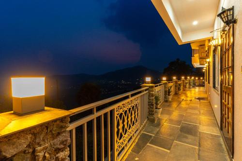 a balcony with a view of a city at night at Peace Stay 2BHK Villa in Bhīm Tāl