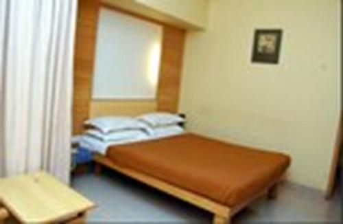 Un dormitorio pequeño con una cama y una ventana. en Hotel City Park, Solapur, en Solapur