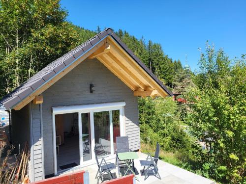 a small house with a porch and a patio at BlackforestBike&HikeHouse in Baiersbronn