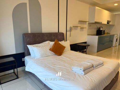 Un dormitorio con una cama con sábanas blancas y almohadas naranjas. en Continew Residence by Janice's Homestay, en Kuala Lumpur