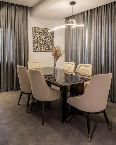 a dining room with a black table and white chairs at George Residence SDA Court, Banana Island, Ikoyi in Lagos