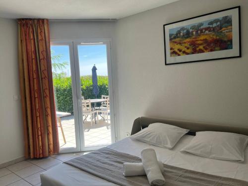 una camera da letto con un letto e un balcone con vista di Le Bord du Lac a Pont-de-lʼIsère