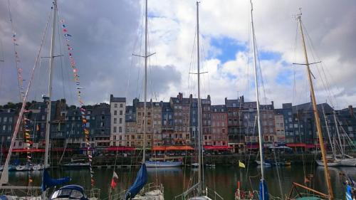 a group of boats docked in a harbor with buildings at La Cabane du Pecheur in Honfleur