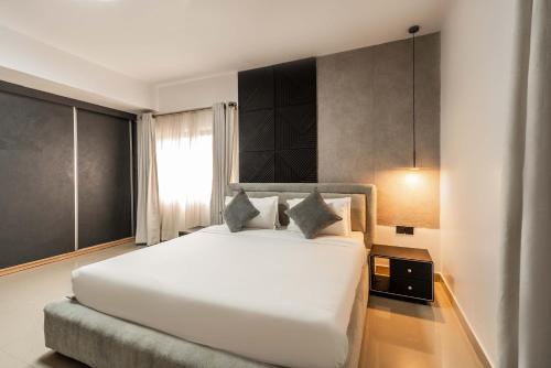 a bedroom with a large white bed and a window at George Residence SDA Court, Banana Island, Ikoyi in Lagos