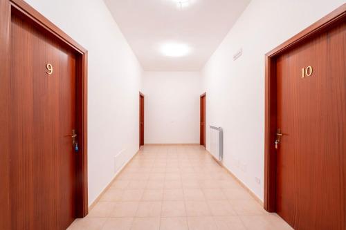 an empty hallway with two doors and a tile floor at Heart's Home - La casa degli amici di Monteverde in Monteverde