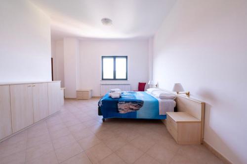 a bedroom with a blue bed in a white room at Heart's Home - La casa degli amici di Monteverde in Monteverde