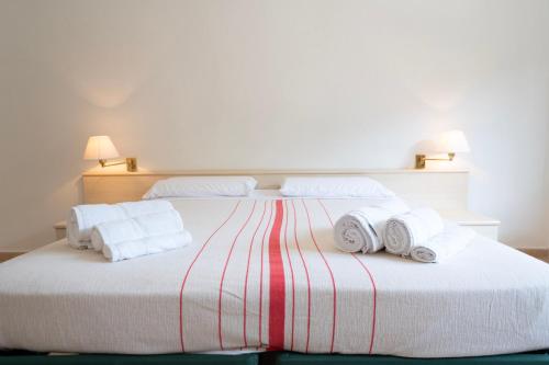 a bedroom with a bed with towels on it at Heart's Home - La casa degli amici di Monteverde in Monteverde