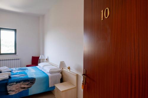 a bedroom with a bed and a red door at Heart's Home - La casa degli amici di Monteverde in Monteverde