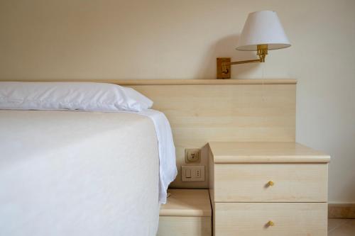 a bedroom with a bed and a nightstand with a lamp at Heart's Home - La casa degli amici di Monteverde in Monteverde
