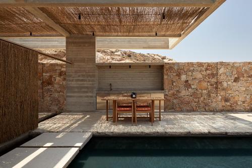 a patio with a table and chairs and a pool at Perma Serifos in Serifos Chora