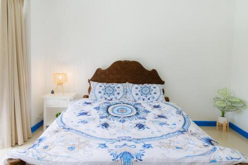 a blue and white bed in a bedroom at Sheva Om in Ban Wat Pho Thong