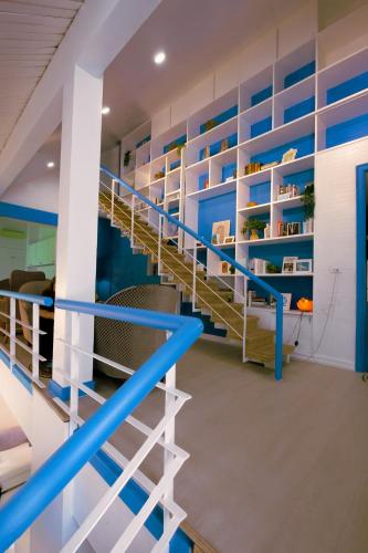 a staircase in a room with blue and white shelving at Sheva Om in Ban Wat Pho Thong