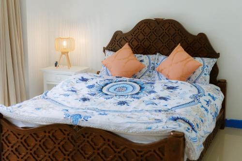 a bed with a blue and white quilt and pillows at Sheva Om in Ban Wat Pho Thong