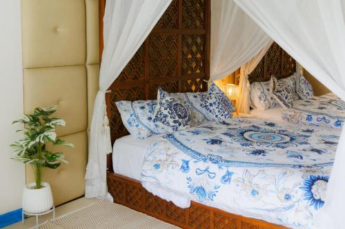 a bedroom with a bed with blue and white pillows at Sheva Om in Ban Wat Pho Thong