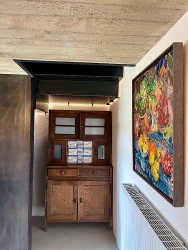 a painting on the wall of a room with a cabinet at Eschette Retreat in Rambrouch