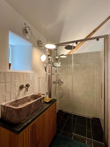 a bathroom with a stone sink and a shower at Eschette Retreat in Rambrouch