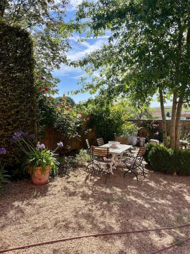 a patio with a table and chairs and flowers at Eschette Retreat in Rambrouch