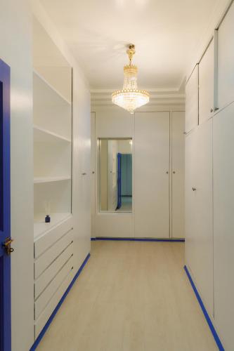 a hallway with white cabinets and a chandelier at Sheva Om in Ban Wat Pho Thong
