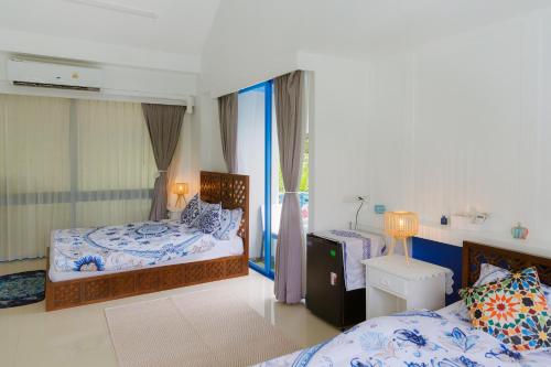 a bedroom with two beds and a window at Sheva Om in Ban Wat Pho Thong