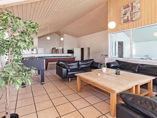 a living room with leather furniture and a pool table at 20 person holiday home in Vinderup-By Traum in Vinderup