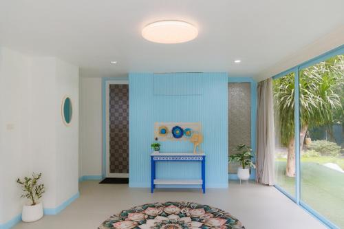 a hallway with blue walls and a blue table at Sheva Om in Ban Wat Pho Thong