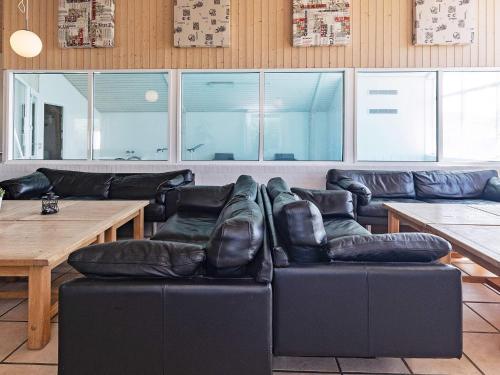 a living room with a black leather couch and a table at 20 person holiday home in Vinderup-By Traum in Vinderup