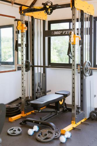 a gym with a bench and other equipment at Sheva Om in Ban Wat Pho Thong